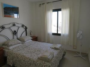 a bedroom with a bed and a window at lidl Bright Central Two Bed Apartment PDC in Puerto del Carmen