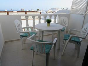 a white table and chairs on a balcony at lidl Bright Central Two Bed Apartment PDC in Puerto del Carmen