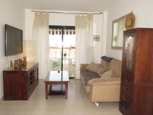 a living room with a couch and a tv at lidl Bright Central Two Bed Apartment PDC in Puerto del Carmen