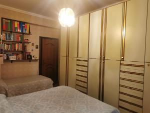 a bedroom with a bed and a book shelf at Comodo appartamento in zona centrale e strategica. in Lamezia Terme
