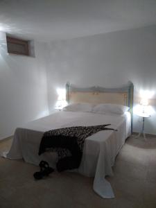 - une chambre avec un grand lit et deux lampes dans l'établissement Villa Fransisca, à Alberobello