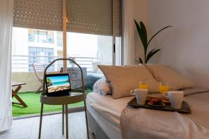 a room with a bed with a table with a laptop on it at NUEVO a estrenar. Vistas al mar, terraza, ascensor in Santa Pola