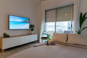 ein Wohnzimmer mit einem Sofa und einem Fernseher an der Wand in der Unterkunft NUEVO a estrenar. Vistas al mar, terraza, ascensor in Santa Pola