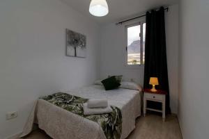 a small bedroom with a bed and a window at Oasis Dakota Duplex in Adeje