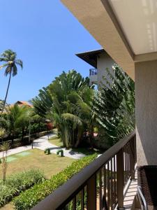 a balcony with a view of a yard with palm trees at Eco Life Beach Class - Muro Alto Flat beira mar in Porto De Galinhas