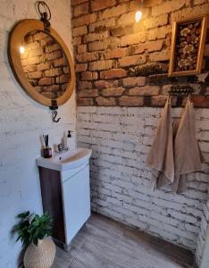 uma casa de banho com um lavatório e uma parede de tijolos em Gluosnių vila - Adutiškio pirtis em Švenčionys