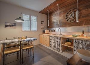 a kitchen with a table and chairs and a sink at Maison 4 jardin - Casa design ai margini del bosco in Crodo
