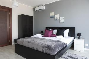 um quarto com uma cama grande e almofadas roxas em Horizont Dedine em Golubac