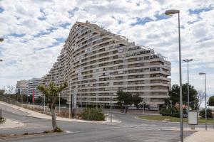 a large white building with a tree in front of it at Florazar 2, Vi-3-B in Faro de Cullera
