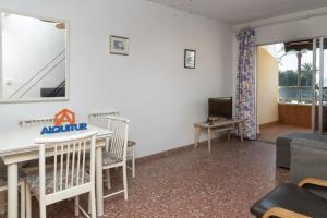 a living room with a table and chairs and a tv at Florazar 2, Vi-3-B in Faro de Cullera