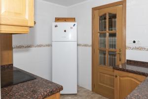 cocina con nevera blanca y puerta de madera en Frontalmar, Esc-A, 8º-29, en Cullera
