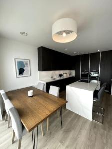 una cucina e una sala da pranzo con tavolo e sedie in legno di Greystones Marina View Penthouse a Greystones