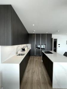 una grande cucina con ripiani bianchi e pavimenti in legno di Greystones Marina View Penthouse a Greystones