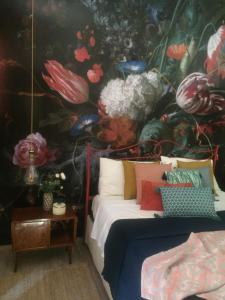 シラクーサにあるIL NIDO DI ARETUSA apt by Addler House Ospitalityの花の壁紙を用いたベッド1台が備わるベッドルーム1室が備わります。