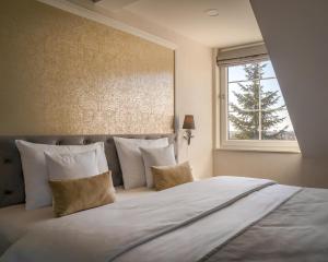 een slaapkamer met een groot bed en een raam bij Merci Boutique Hotel in Krakau