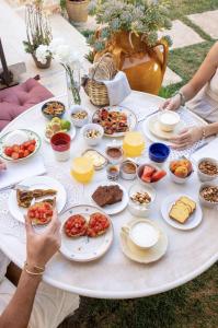 ein weißer Tisch mit Teller mit Lebensmitteln drauf in der Unterkunft Masseria San Paolo Grande in Ostuni