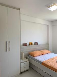 a white bedroom with a bed and a mirror at Eco Life Beach Class - Muro Alto Flat beira mar in Porto De Galinhas