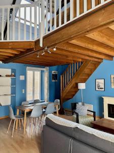 sala de estar con paredes azules y escalera de madera en L'hippocampe - appt mezzanine centre d'Arromanches en Arromanches-les-Bains