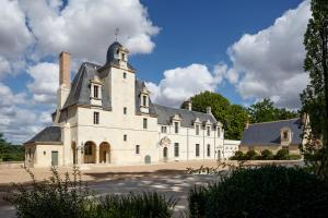 Reugny的住宿－Relais & Château Louise de La Vallière，一座白色的大建筑,顶部有塔