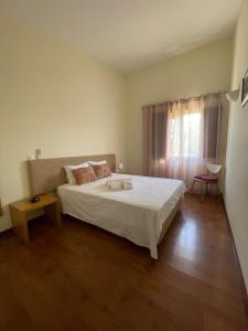 a bedroom with a white bed and a window at Herdade do Gizo - Casa Reis in Cuba