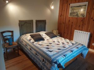 1 dormitorio con 1 cama y 1 silla en Maison de Sao en pierres, en Lablachère