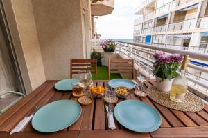 einen Tisch mit blauen Tellern und Weingläsern auf dem Balkon in der Unterkunft NUEVO a estrenar. Vistas al mar, terraza, ascensor in Santa Pola