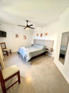 1 dormitorio con 1 cama y ventilador de techo en Lumiere Apartments - Luminoso Departamento en Complejo Residencial en Mendoza