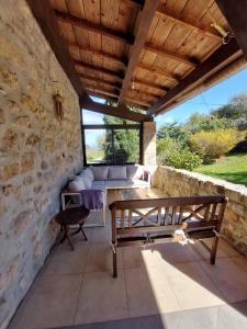 un patio con un banco de madera y una mesa en Maison de Sao en pierres, en Lablachère