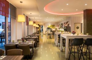 a restaurant with tables and chairs and a bar at Leonardo Hotel Berlin Mitte in Berlin