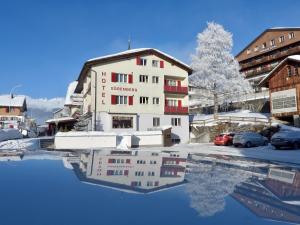 a reflection of a building in a pool of water at Hotel Sörenberg in Sörenberg