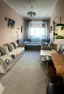 uma sala de estar com um sofá e uma mesa em Apartament przy Dworcu em Radom