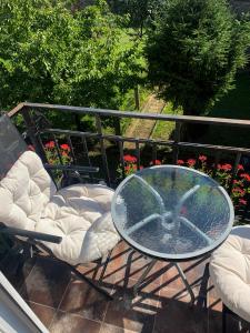 een glazen tafel en een stoel op een patio bij Apartament przy Dworcu in Radom