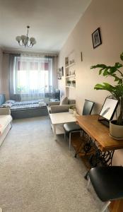 uma sala de estar com uma mesa e um sofá em Apartament przy Dworcu em Radom
