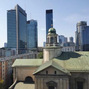 an old building with a clock tower in a city at Center Apartment in Warsaw