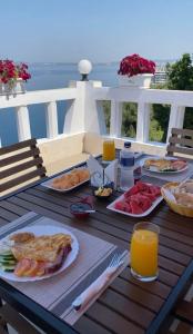 una tavola con piatti di cibo e succo d'arancia di Seascape Villas a Vlorë