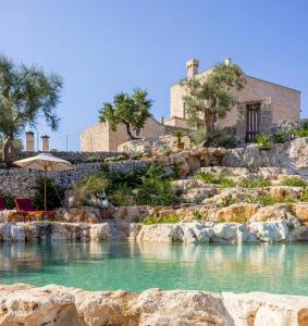 a house on a hill with a pool of water at Masseria San Paolo Grande in Ostuni +260 photos