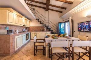 cocina con mesa y sillas y TV en Sardinia Home, en Palau