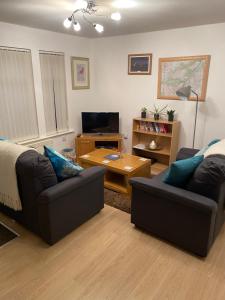 a living room with two couches and a television at SCOTTISH HIGHLANDS Superb 2 bedroom apartment. in Invergarry