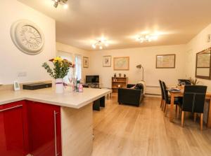 a kitchen and dining room with a table and a clock on the wall at SCOTTISH HIGHLANDS Superb 2 bedroom apartment. in Invergarry