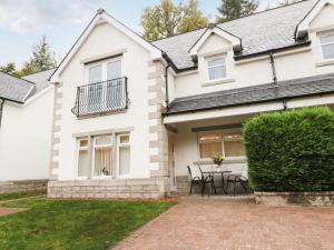 a white house with a table in front of it at SCOTTISH HIGHLANDS Superb 2 bedroom apartment. in Invergarry