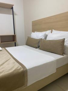 1 dormitorio con 1 cama grande con sábanas y almohadas blancas en Hotel Central, en Sincelejo