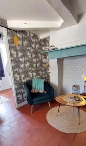 een woonkamer met een stoel en een open haard bij La petite Dieppoise 3 étoiles meublé de tourisme Entre plage et port in Dieppe