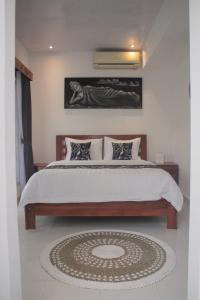 a bedroom with a large bed and a rug at Summer Homestay Bali in Nusa Dua