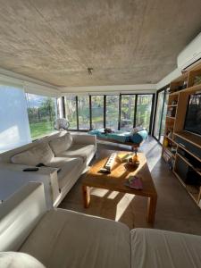 sala de estar con sofá blanco y mesa en La Nube - San Lorenzo en San Lorenzo