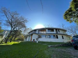 duży biały dom na szczycie trawiastego wzgórza w obiekcie La Nube - San Lorenzo w mieście San Lorenzo