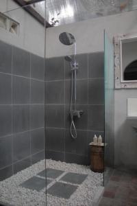 a shower with a glass door in a bathroom at Summer Homestay Bali in Nusa Dua