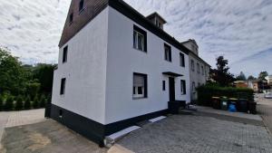 a white building with a black roof at Apartments Overath in Overath