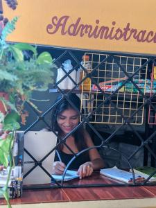 a woman sitting at a table reading a book at Hotel Hacienda la Alborada in Tuxtla Gutiérrez