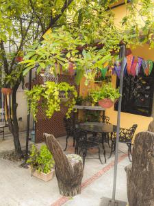 un patio con mesa, sillas y plantas en Hotel Hacienda la Alborada, en Tuxtla Gutiérrez