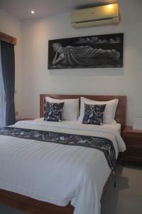 a bedroom with a large bed with white sheets and pillows at Summer Homestay Bali in Nusa Dua